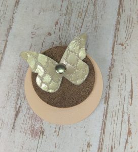 broche ronde en cuir rose poudré et marron irisé avec papillon en cuir nude texturé écailles